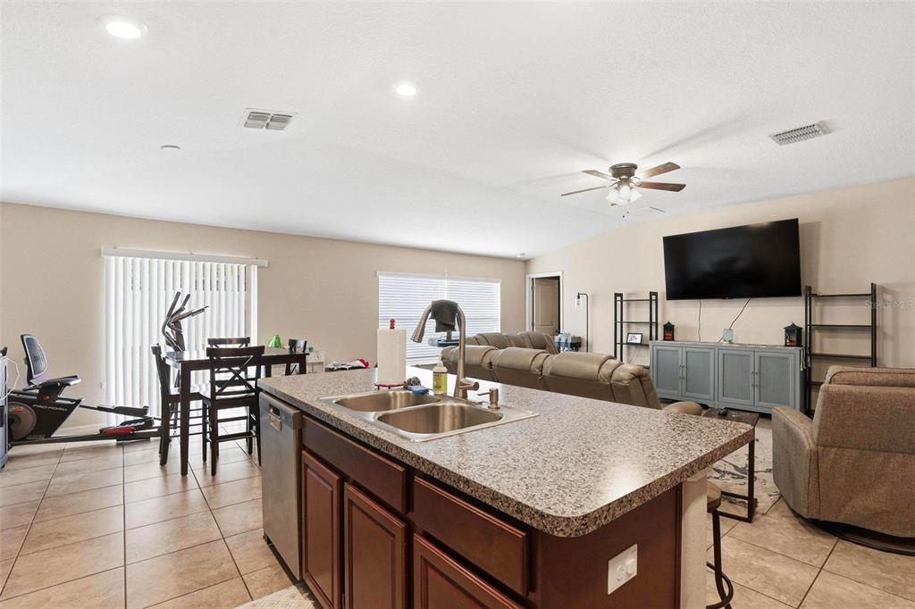 211 English Channel Place Dover, FL 33527 - Photo 25 of 35 a kitchen with a stove a sink a dining table and chairs
