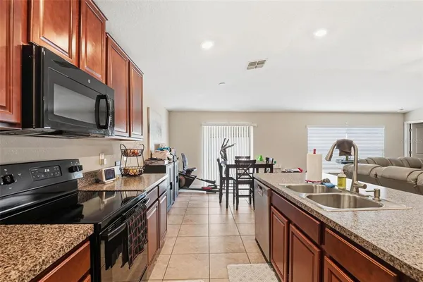 a kitchen with granite countertop stainless steel appliances a stove sink microwave and cabinets
