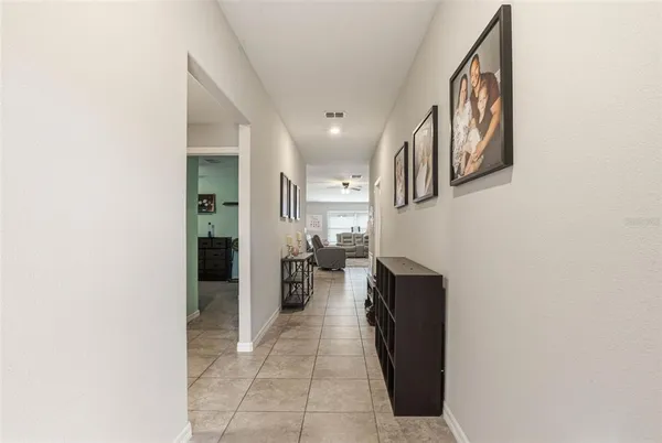 a hallway with a view of living room with a mirror