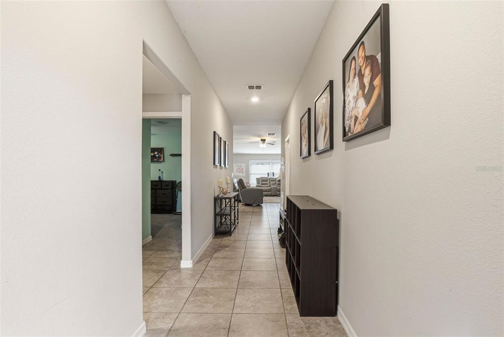 211 English Channel Place Dover, FL 33527 - Photo 5 of 35 a hallway with a view of living room with a mirror