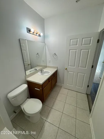 a bathroom with a toilet a sink a mirror and vanity