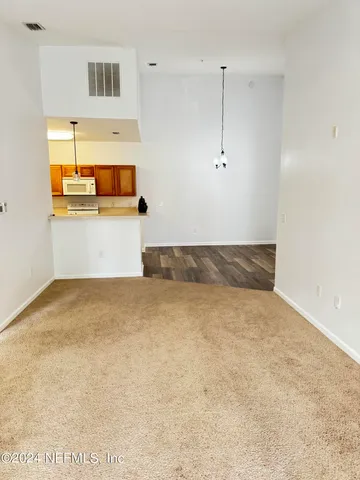 a view of a livingroom with a chandelier fan and windows