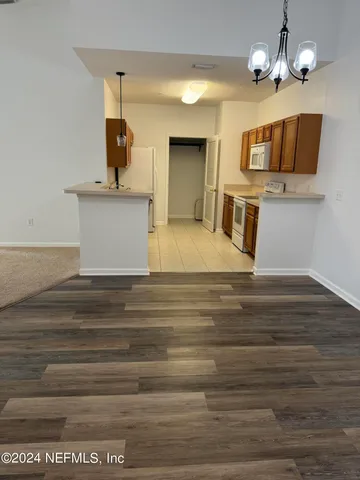 a view of a kitchen with a sink and chandelier
