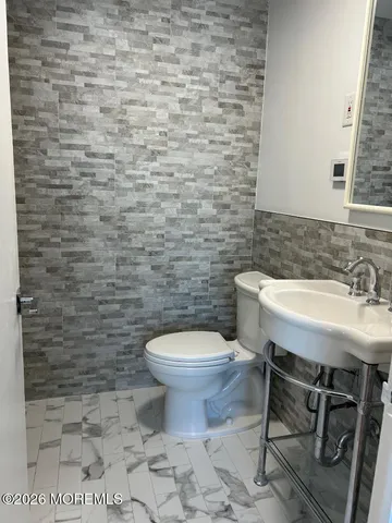 a bathroom with a granite countertop toilet sink and mirror