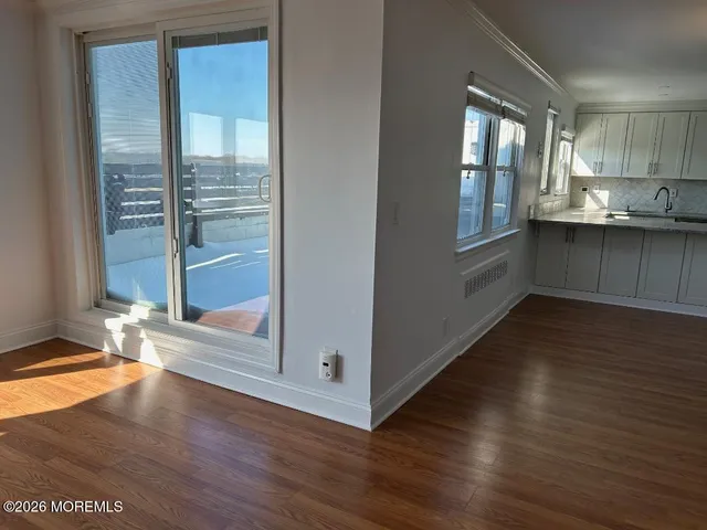 a kitchen with stainless steel appliances granite countertop a sink dishwasher a stove a dining table and chairs with wooden floor