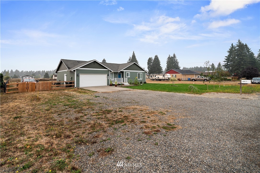 18011 Daryl Lane Southwest Rochester, WA 98579 - Photo 2 of 31 a front view of a house with a yard and garage