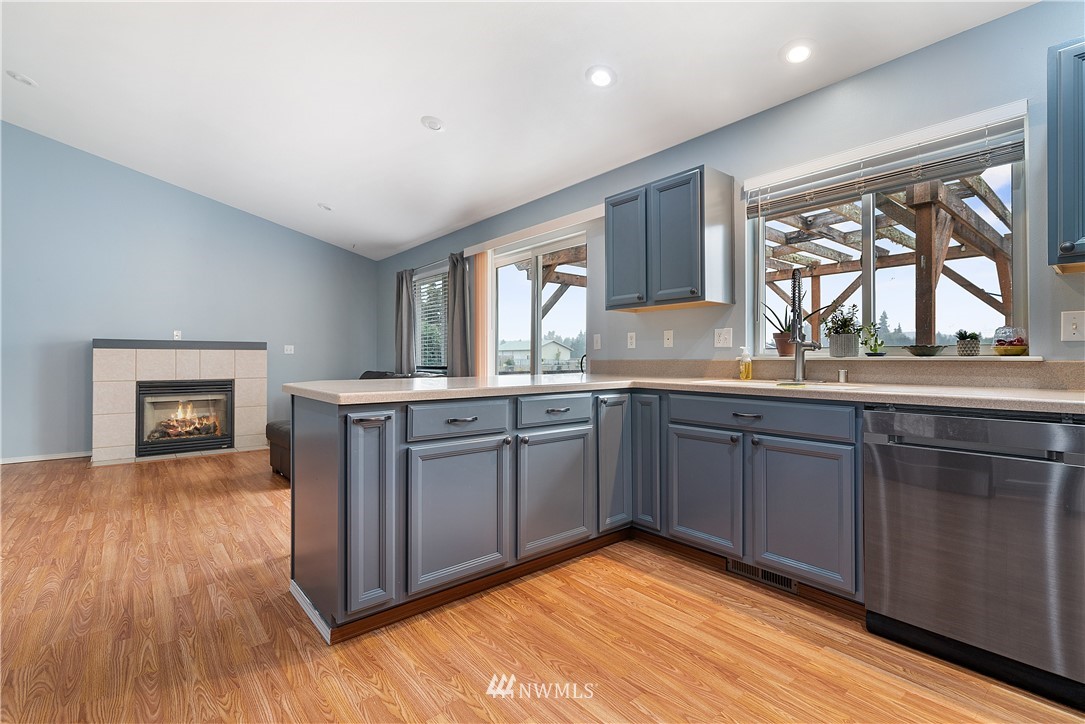 18011 Daryl Lane Southwest Rochester, WA 98579 - Photo 19 of 31 a kitchen with granite countertop a stove a sink wooden floor and a window
