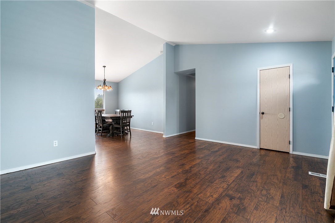 18011 Daryl Lane Southwest Rochester, WA 98579 - Photo 9 of 31 an empty room with wooden floor and a hallway