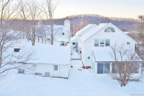 a view of a white house with a snow in the background