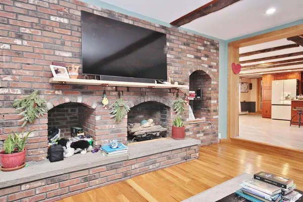 a kitchen with stainless steel appliances granite countertop a refrigerator a sink a stove and a wooden floors