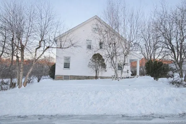 a view of white house with a snow on the road