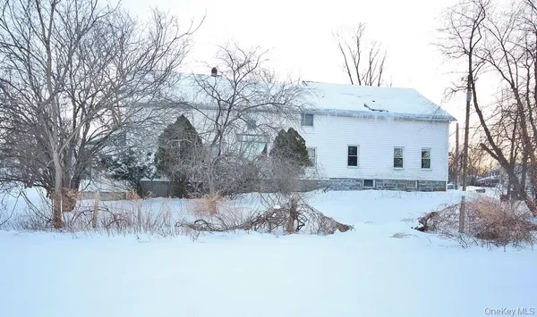 a front view of a house with a yard covered in snow