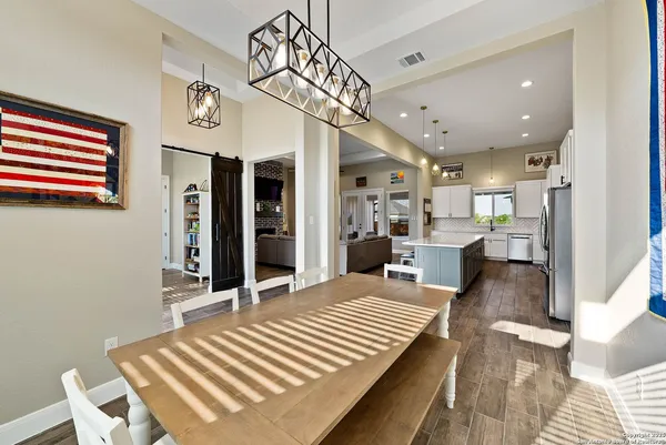 a view of a dining room and livingroom with furniture wooden floor a chandelier