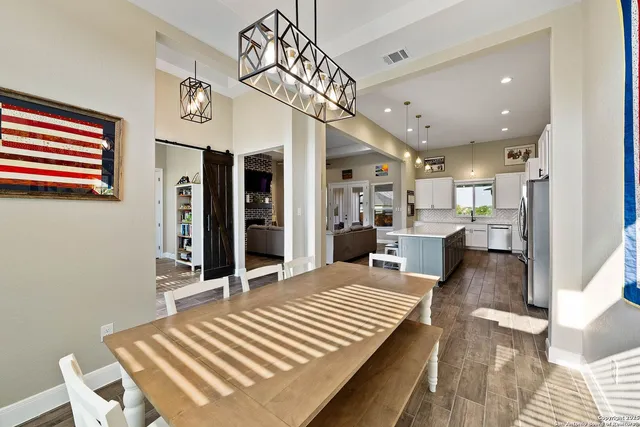 a view of a dining room and livingroom with furniture wooden floor a chandelier