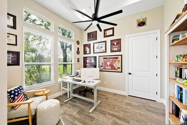 a living room with furniture a bookshelf and a window