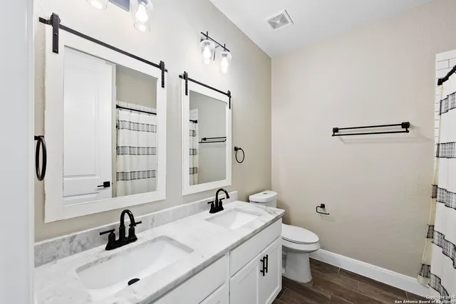 a bathroom with a sink toilet a mirror and shower