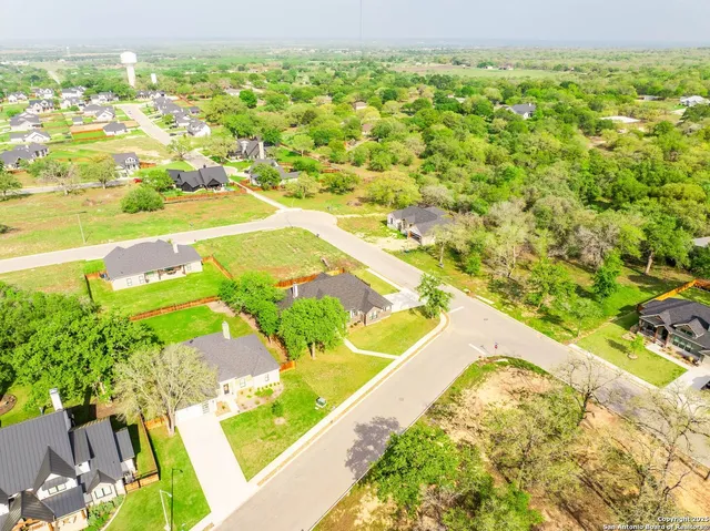 a view of swimming pool with lawn chairs and large trees