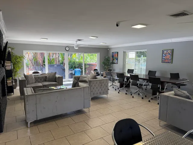 a living room with furniture a large window and stainless steel appliances