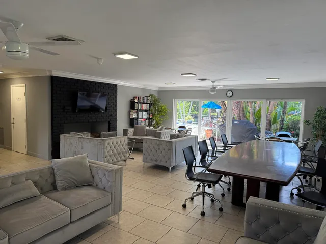 a living room with furniture a flat screen tv and a table