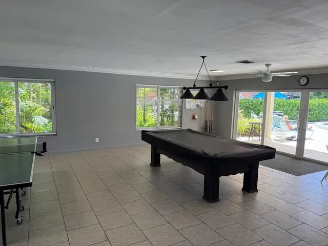 a room with pool table and windows