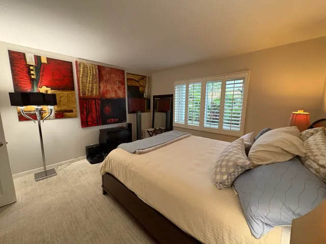 a bedroom with a bed and dresser with mirror