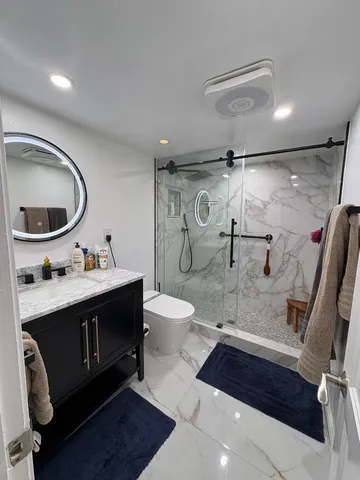 a bathroom with a sink a toilet and shower