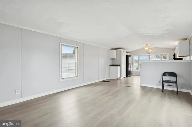 a view of an empty room with window and wooden floor