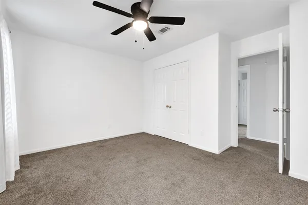 an empty room with chandelier fan