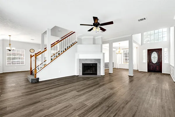 a view of an empty room with wooden floor fireplace and a window