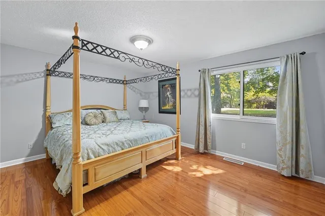 a bedroom with a bed and a painting on the wall