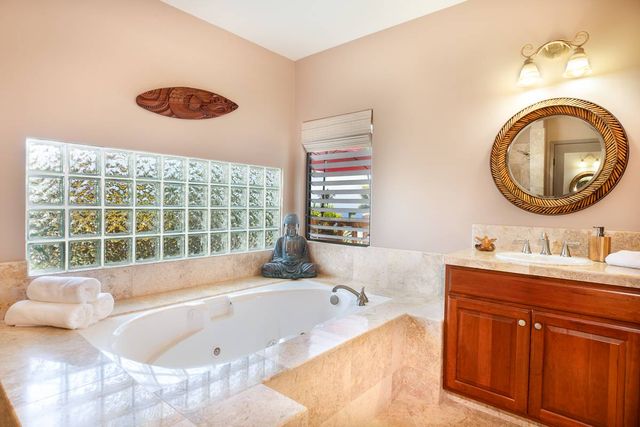 a bathroom with a tub sink and mirror