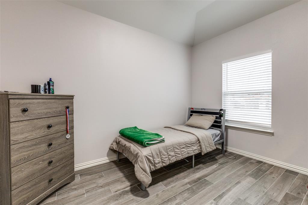 8730 Dunlap Street Dallas, TX 75217 - Photo 12 of 15 a bed sitting in a bedroom next to a window and dresser