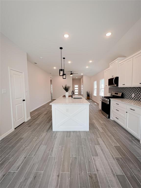 8730 Dunlap Street Dallas, TX 75217 - Photo 3 of 15 a large kitchen with stainless steel appliances kitchen island granite countertop a large counter top a sink and a stove with wooden floor