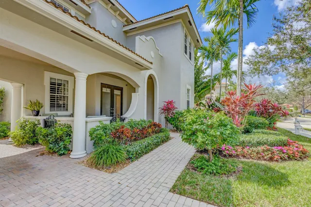 a view of a house with a yard and potted plants