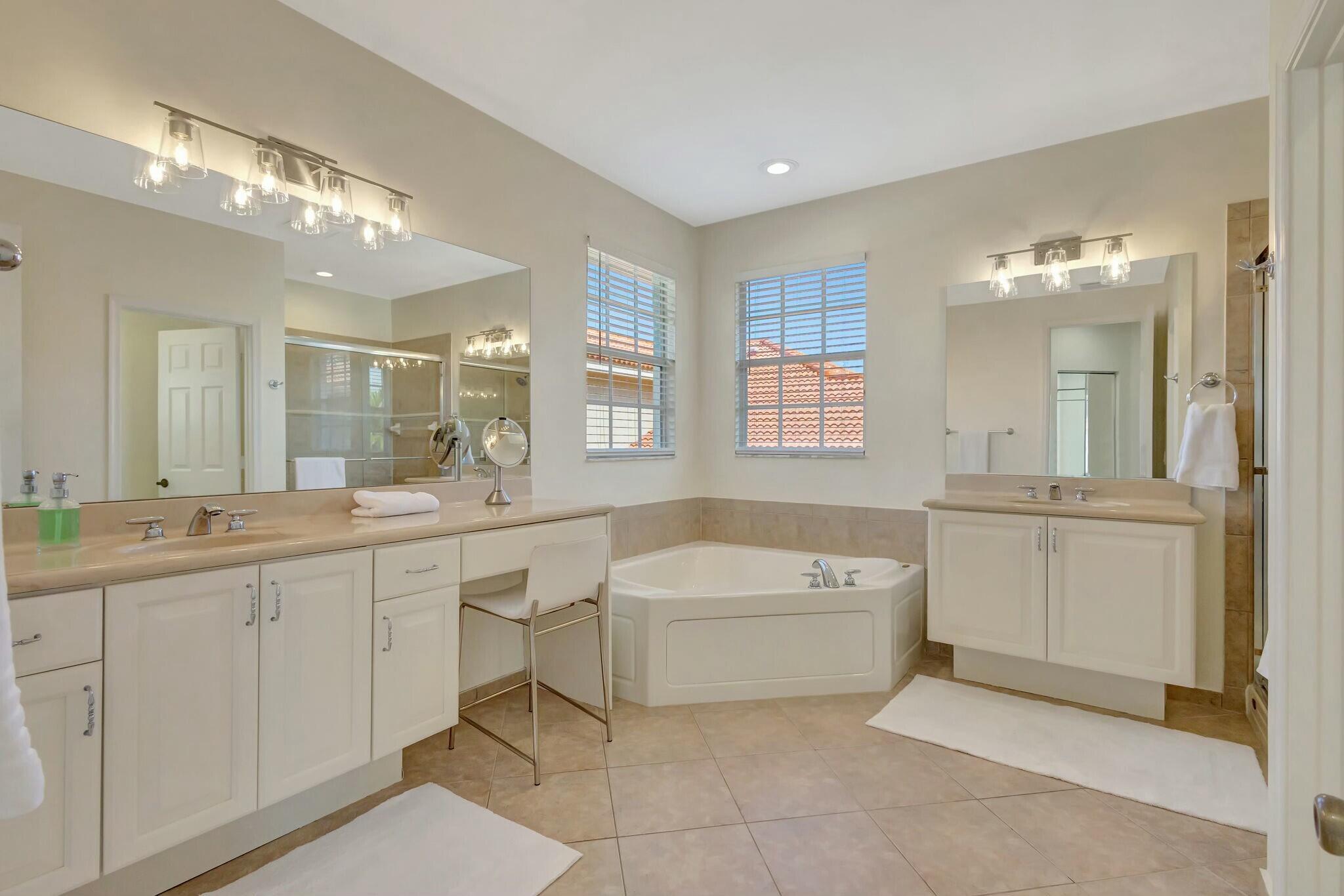 106 Via Santa Cruz Jupiter, FL 33458 - Photo 43 of 71 a bathroom with a large tub sink vanity granite and a shower