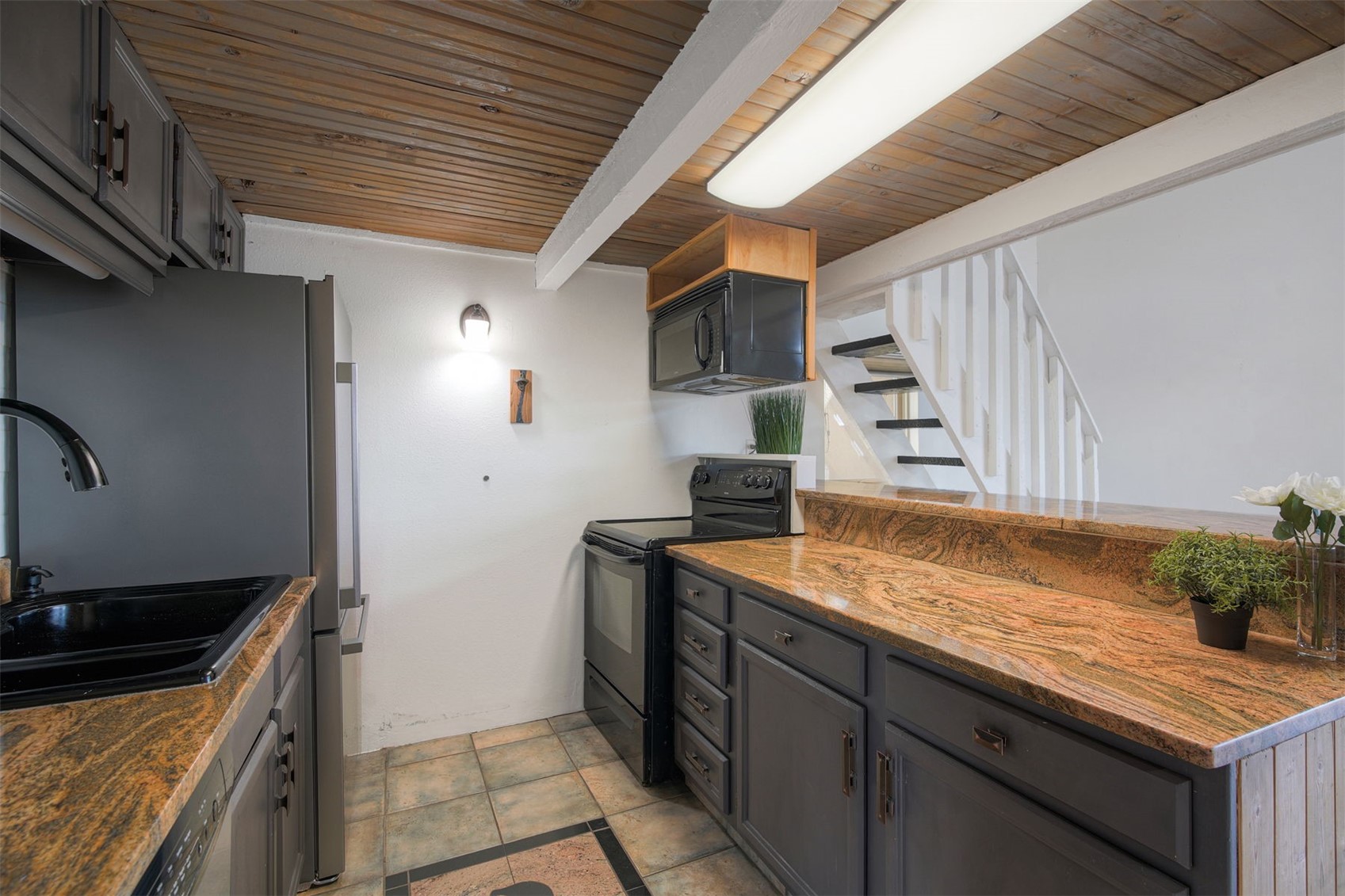 7031 Ryan Gulch Road, Unit 301 Silverthorne, CO 80498 - Photo 11 of 37 a kitchen that has a sink and a stove