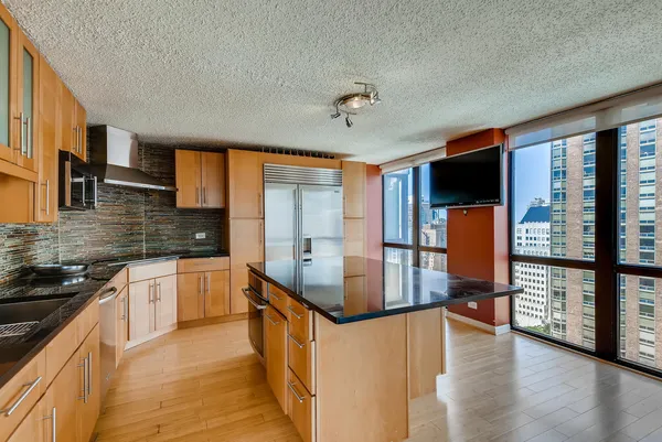 a kitchen with stainless steel appliances granite countertop a stove top oven a sink and a refrigerator