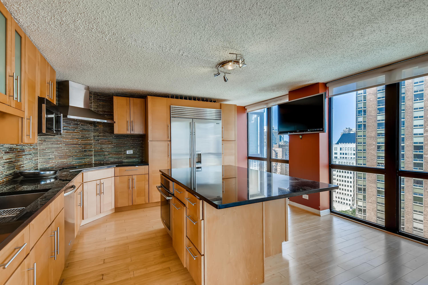 1122 North Clark Street, Unit 2208 Chicago, IL 60610 - Photo 5 of 11 a kitchen with stainless steel appliances granite countertop a stove top oven a sink and a refrigerator