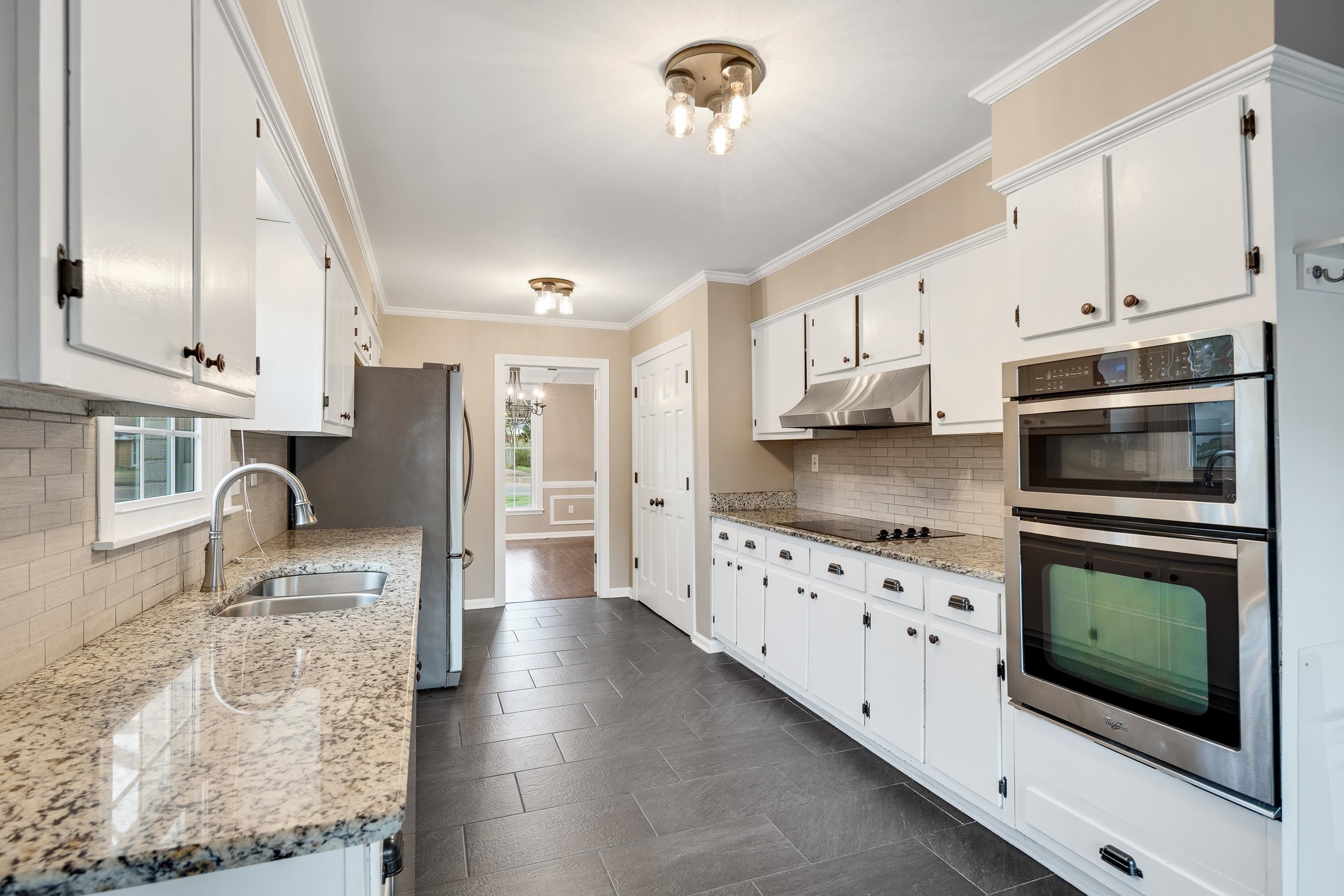 1658 Miller Farms Road Germantown, TN 38138 - Photo 11 of 39 Kitchen featuring stainless steel appliances, white cabinets, ornamental molding, light stone countertops, and suspended lighting