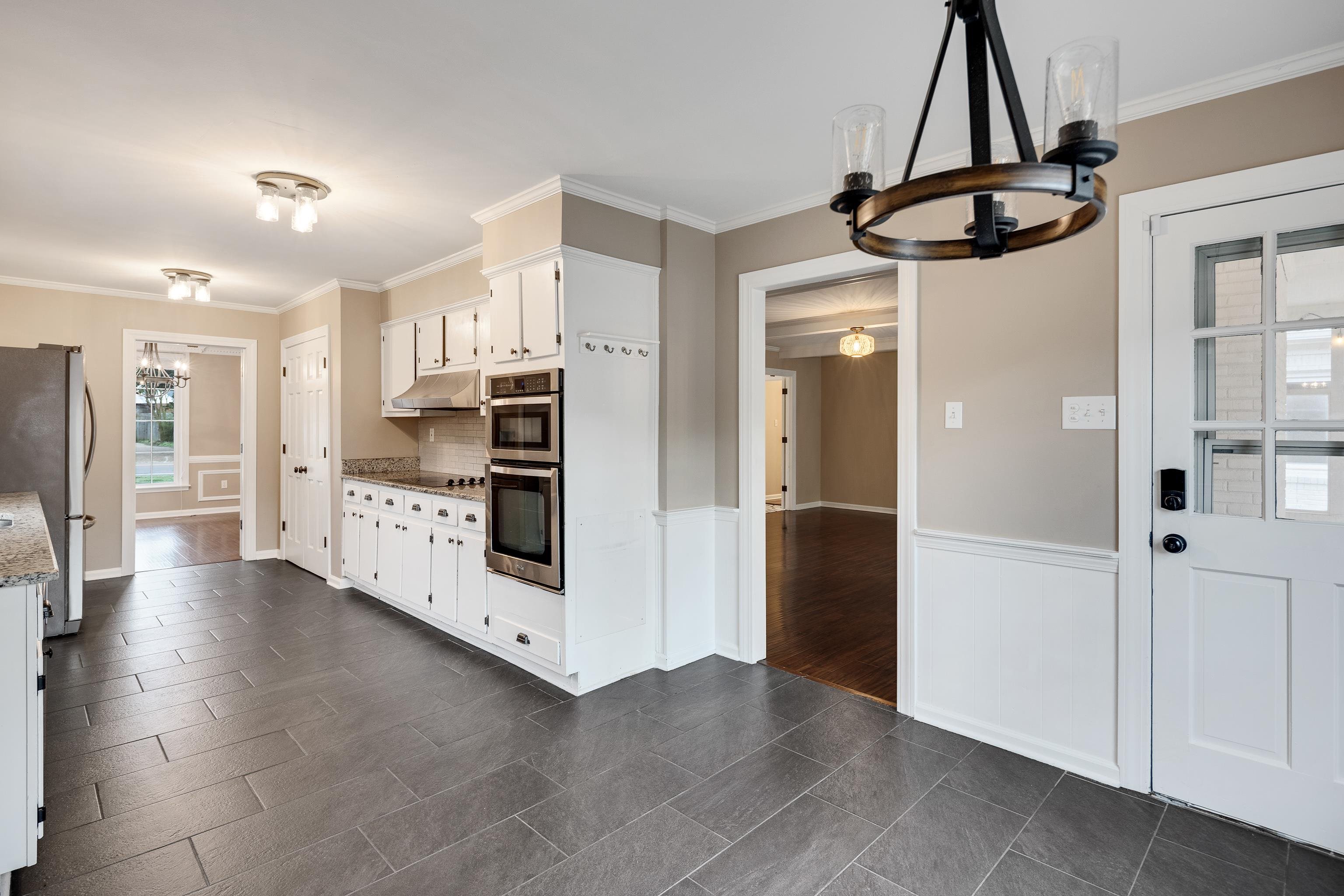 1658 Miller Farms Road Germantown, TN 38138 - Photo 12 of 39 Kitchen with hanging lights, crown molding, white cabinets, stainless steel appliances, and dark tile patterned flooring