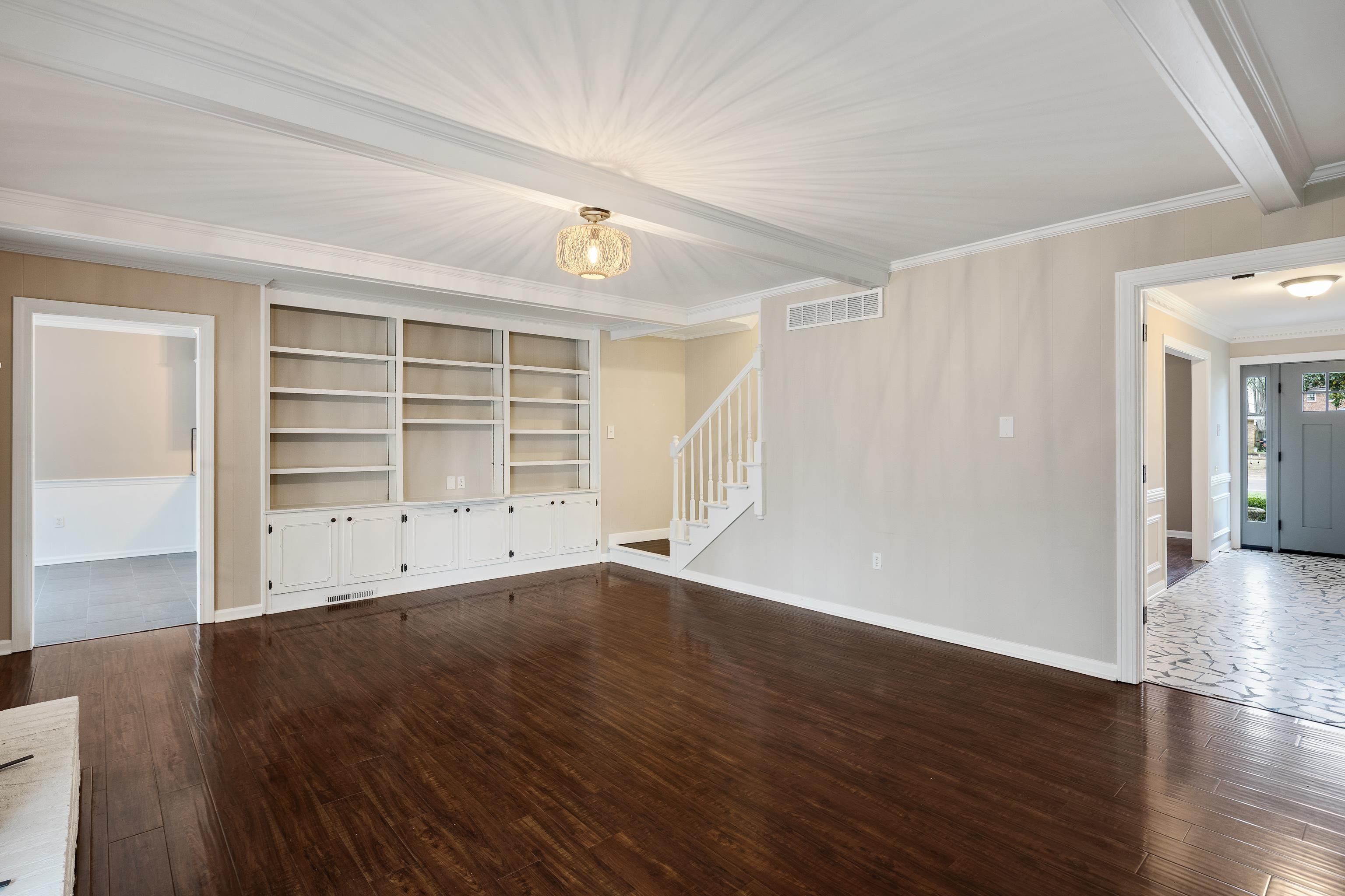 1658 Miller Farms Road Germantown, TN 38138 - Photo 15 of 39 Unfurnished living room with dark wood finished floors, beamed ceiling, ornamental molding, and built in shelves