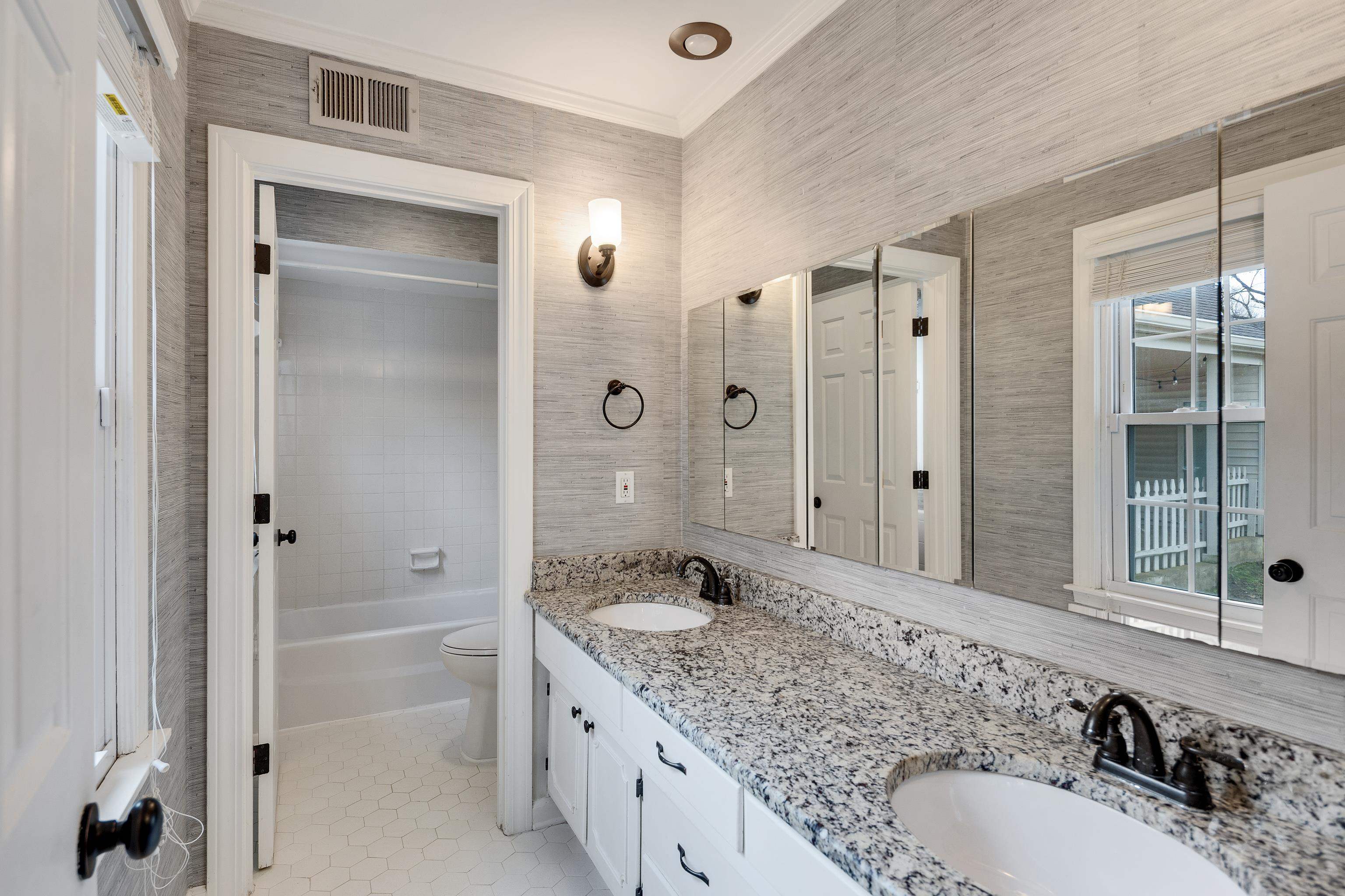 1658 Miller Farms Road Germantown, TN 38138 - Photo 18 of 39 Bathroom with double vanity, crown molding, light tile patterned floors, tub / shower combination, and wallpapered walls