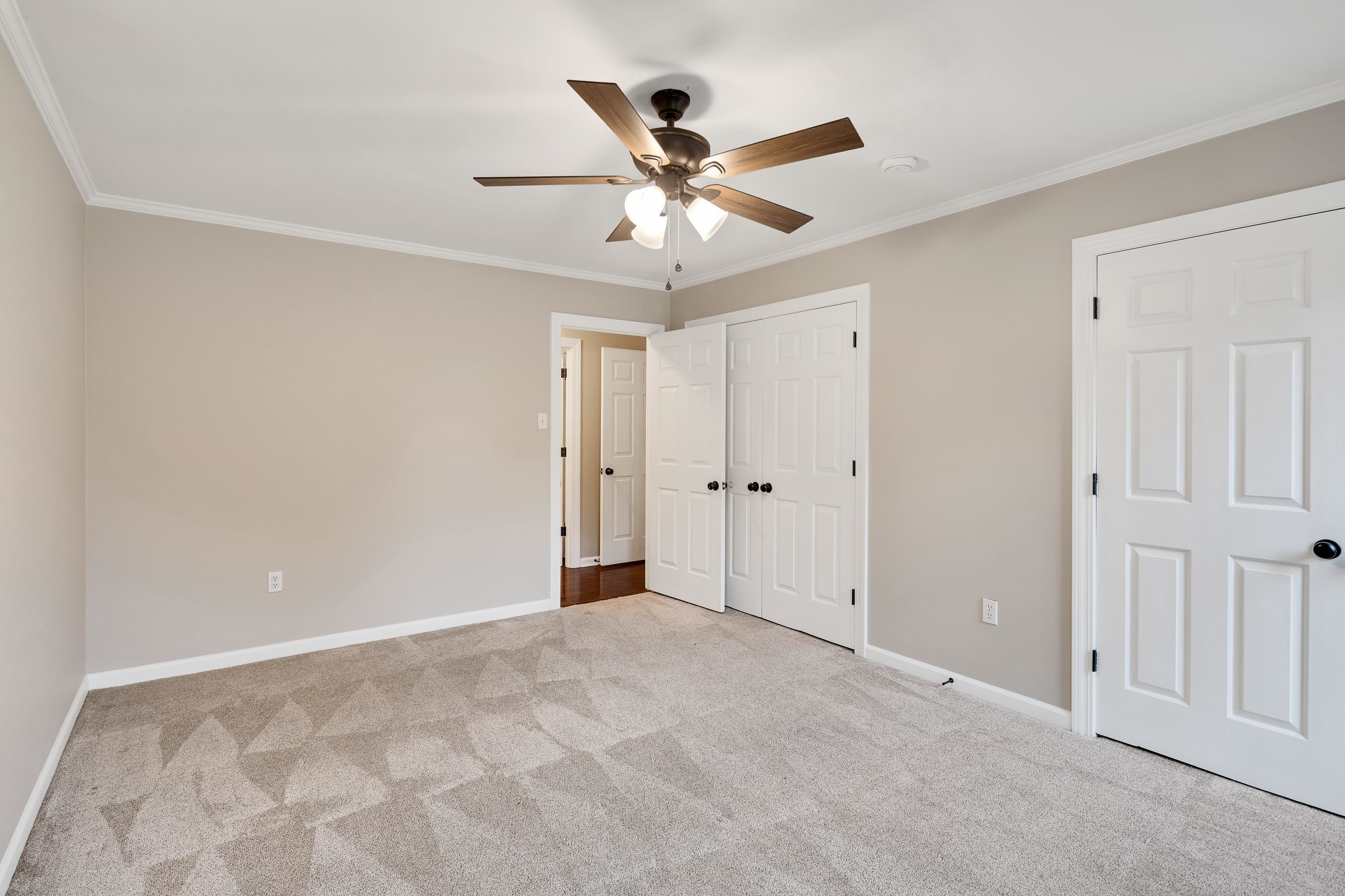 1658 Miller Farms Road Germantown, TN 38138 - Photo 24 of 39 Unfurnished bedroom with crown molding, light carpet, a ceiling fan, and two closets