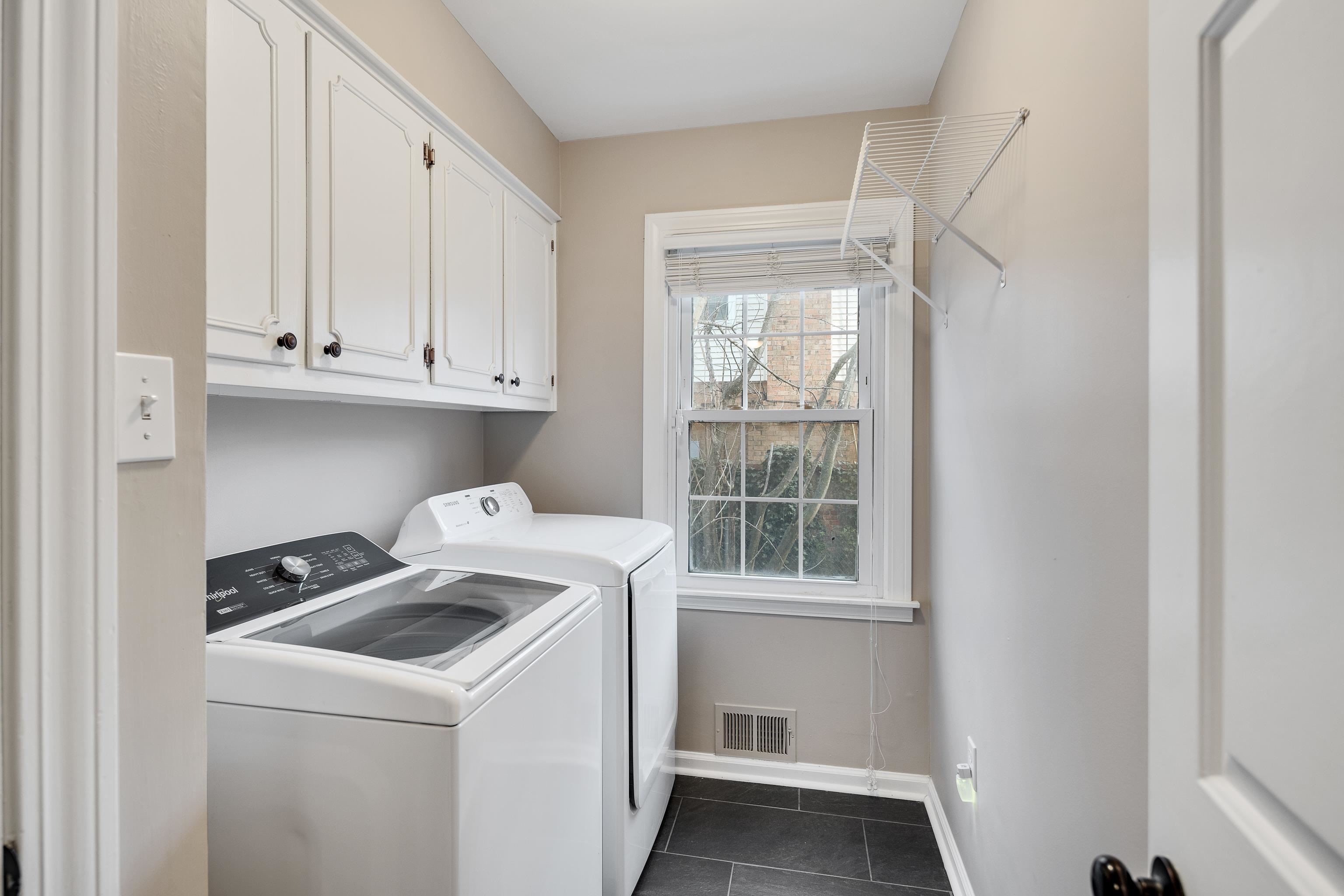 1658 Miller Farms Road Germantown, TN 38138 - Photo 25 of 39 Laundry area featuring cabinet space, washer and clothes dryer, and dark tile patterned floors
