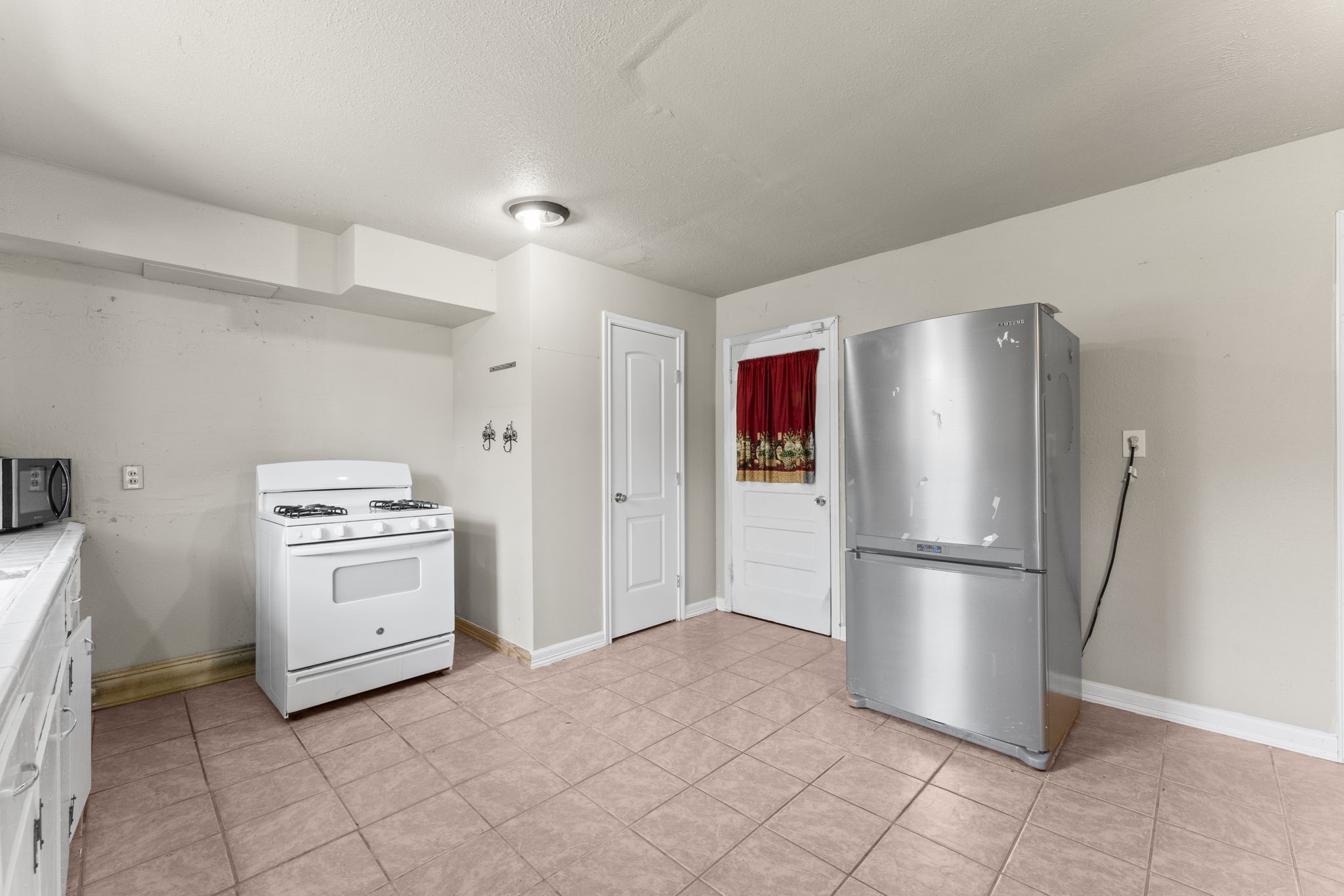 814 Isetta Lane Houston, TX 77060 - Photo 11 of 30 a kitchen with a refrigerator stove and white cabinets