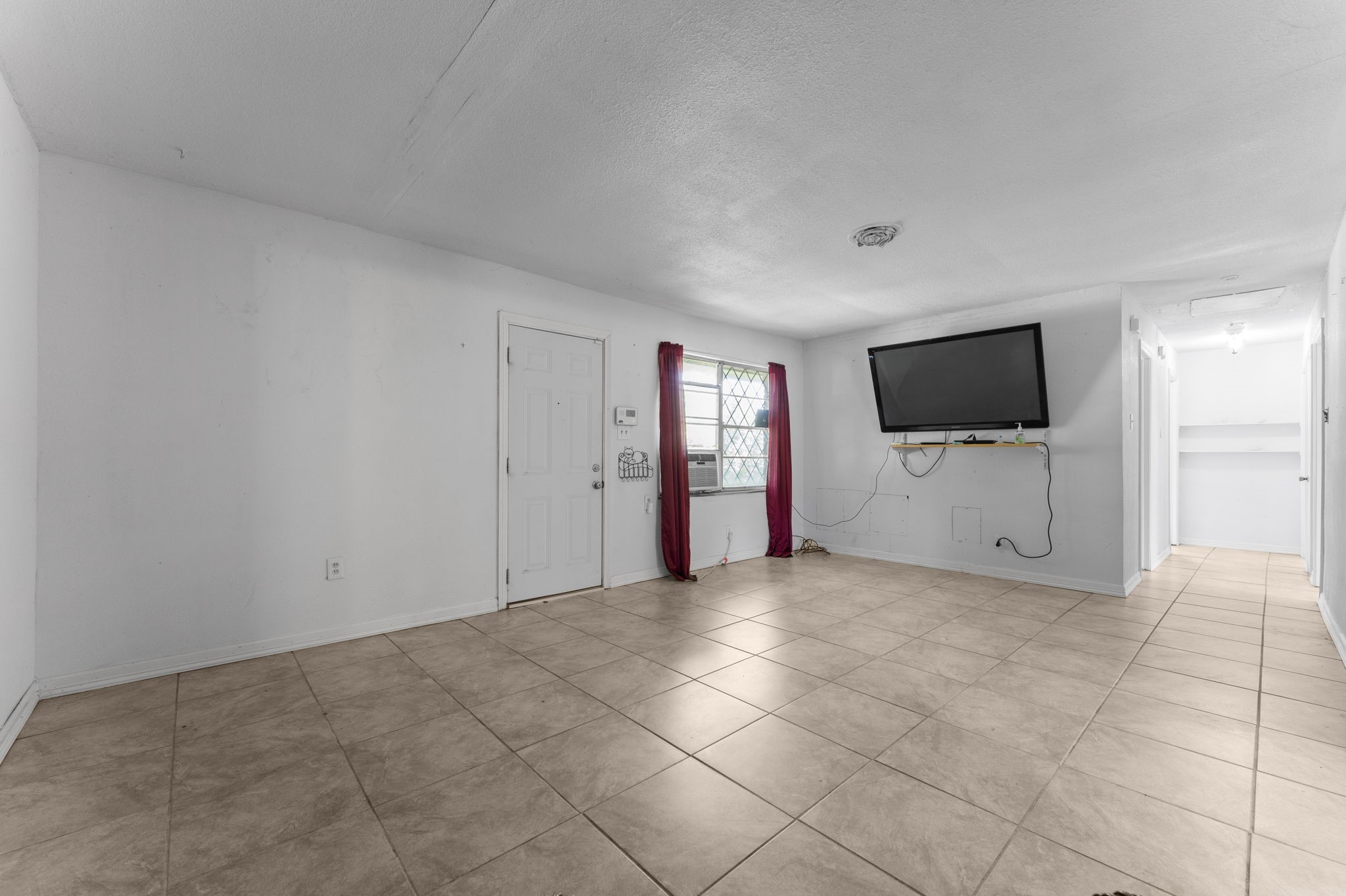 814 Isetta Lane Houston, TX 77060 - Photo 8 of 30 a view of an empty room with a flat screen tv and kitchen view