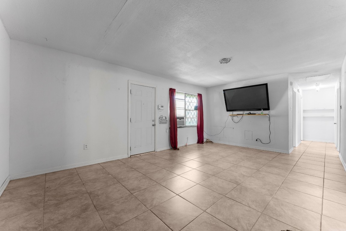 814 Isetta Lane Houston, TX 77060 - Photo 8 of 30 a view of an empty room with a flat screen tv and kitchen view