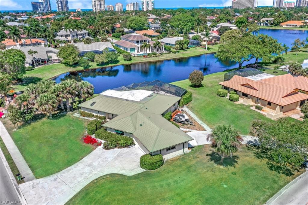 619 Neapolitan Way Naples, FL 34103 - Photo 1 of 32 an aerial view of a house with swimming pool tennis courts and ocean view
