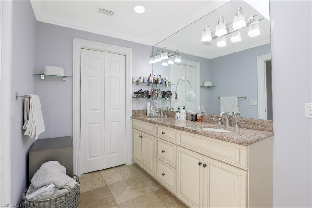 619 Neapolitan Way Naples, FL 34103 - Photo 14 of 32 a bathroom with a double vanity sink and a mirror