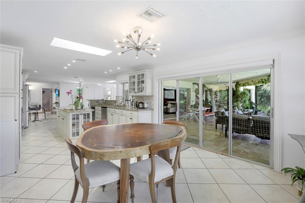 619 Neapolitan Way Naples, FL 34103 - Photo 16 of 32 a dining room with furniture and a floor to ceiling window